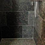 barrierefreie Dusche mit zentriertem Bodenablauf aus Naturstein Granit, Steel Grey, satiniert